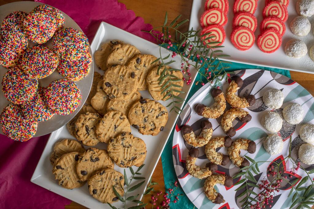From left, Sprinkle Sugar cookies, Peanut Butter Chocolate Chip, Gluten-free chocolate-dipped Almond Crescents, Peppermint Pinwheels, and Pecan Butter Balls. (photo by John Burgess/The Press Democrat)