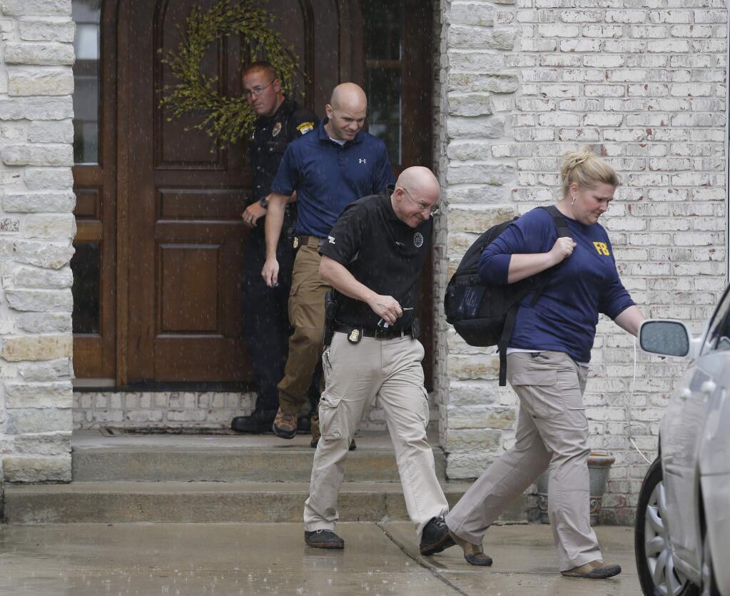 Federal authorities walk out of the home of Subway restaurant spokesman Jared Fogle, Tuesday, July 7, 2015, in Zionsville, Ind. FBI agents and Indiana State Police have removed electronics from the property. FBI Special agent Wendy Osborne said Tuesday that the FBI was conducting an investigation in the Zionsville area but wouldn't confirm it involved Fogle. (AP Photo/Michael Conroy)