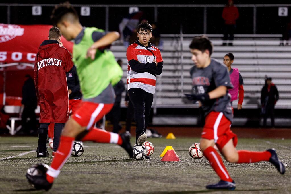 Montgomery Vikings varsity soccer team manager Josh Vieyra, center, watches his teammates warm up before their NCS Division 2 playoff game against Windsor High School, in Santa Rosa on Wednesday, February 13, 2019. (Alvin Jornada / The Press Democrat)