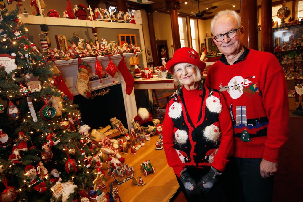 Judy and Steve Everett pose for a portrait beside a portion of their Santa Claus collection, which is on display at the Healdsburg Museum through January 6, in Healdsburg, California, on Thursday, December 6, 2018. (Alvin Jornada / The Press Democrat)