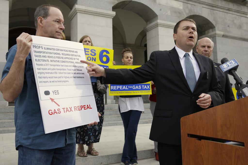 Carl DeMaio, who is leading the Proposition 6 campaign to repeal a recent gas tax increase, gestures towards a mockup of a ballot calling for voters to approve Prop. 6 on the November ballot, during a new conference Monday, Oct. 29, 2018, in Sacramento, Calif. DeMaio says that if the bid fails he'll seek to recall Democratic Attorney General Xavier Becerra saying Becerra wrote a deceiving ballot title. (AP Photo/Rich Pedroncelli)