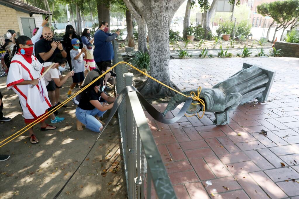 Activists topple the statue of Father Junípero Serra at Father Serra Park in El Pueblo de Los Angeles on June 20. (GARY CORONADO / Los Angeles Times)