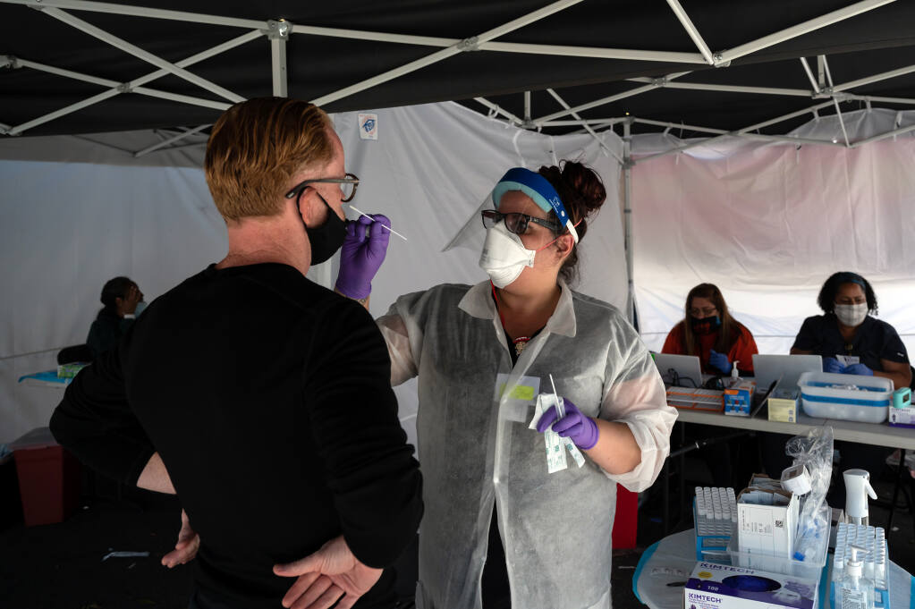 A person is swabbed for a COVID-19 test by a health care worker at a community vaccination and testing site in the Mission District of San Francisco, Aug. 1, 2021.  (Mike Kai Chen/The New York Times)