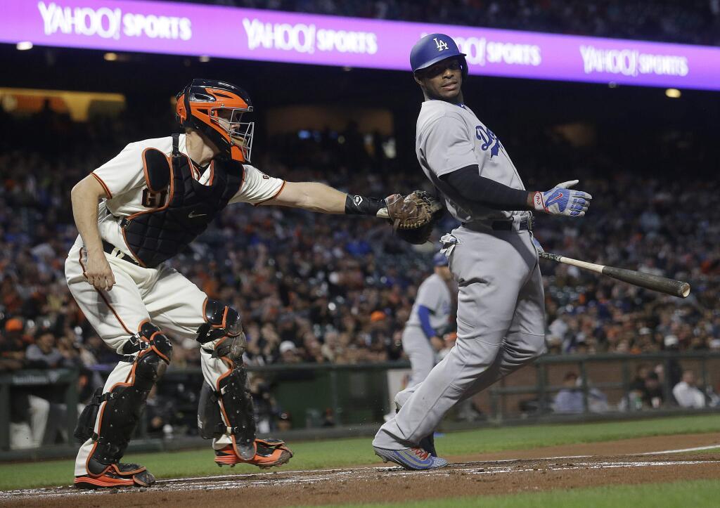 Los Angeles Dodgers' Yasiel Puig, right, is tagged by San Francisco Giants catcher Nick Hundley after striking out during the first inning in San Francisco, Tuesday, Sept. 12, 2017. (AP Photo/Jeff Chiu)