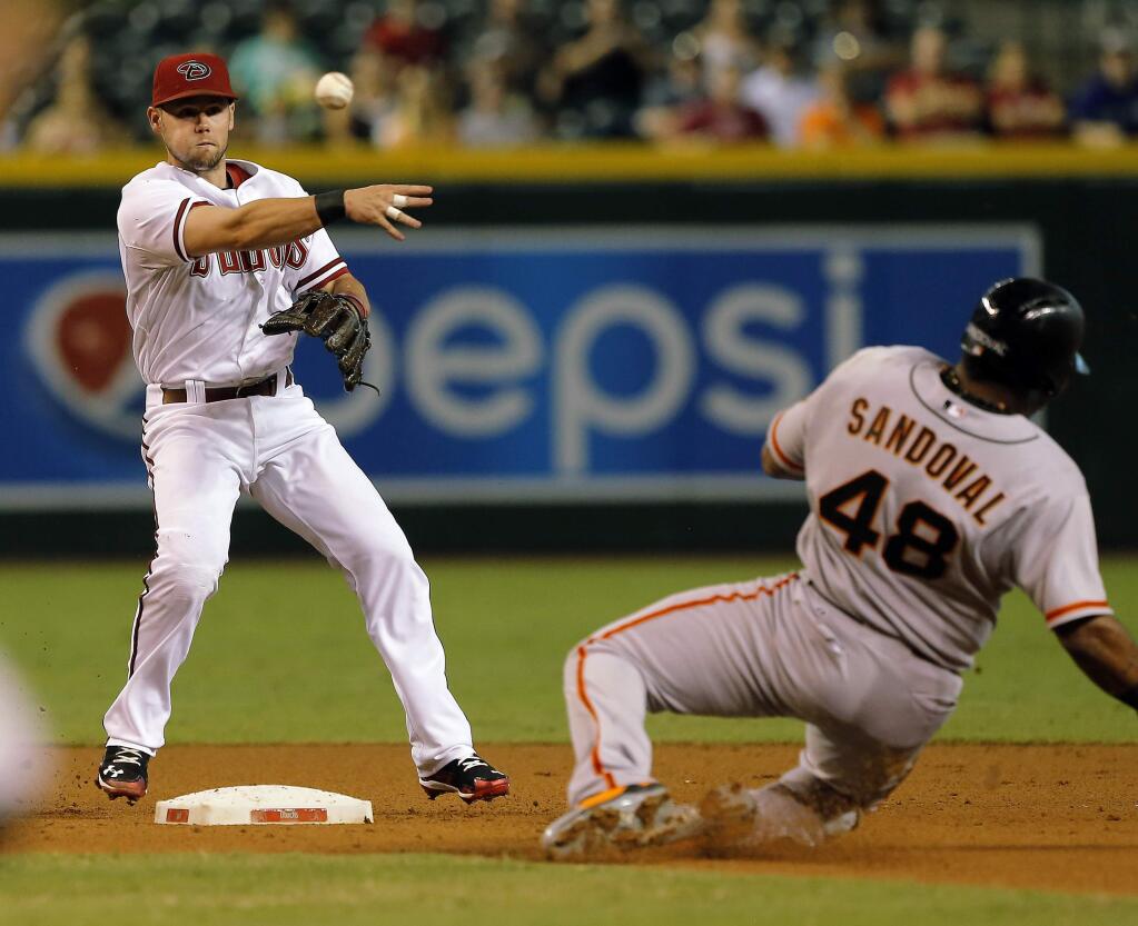 Arizona Diamondbacks shortstop Chris Owings turns the double play while avoiding San Francisco Giants Pablo Sandoval (48) in the second inning during a baseball game, Tuesday, Sept. 16, 2014, in Phoenix. (AP Photo/Rick Scuteri)