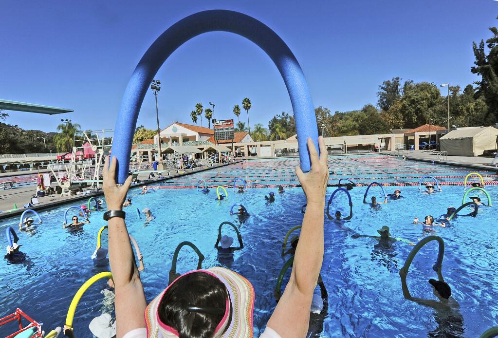 Swim instructor Daphne Trager leads an exercise session at Rose Bowl Aquatics Center in Pasadena, Calif., Monday, Oct. 23, 2017. Temperatures in some parts of Southern California climbed into the upper 90s and over 100 on Monday as authorities warned of several days of dangerously high heat plus gusty Santa Ana winds that boost the risk of wildfires. (Walt Mancini/Los Angeles Daily News via AP)