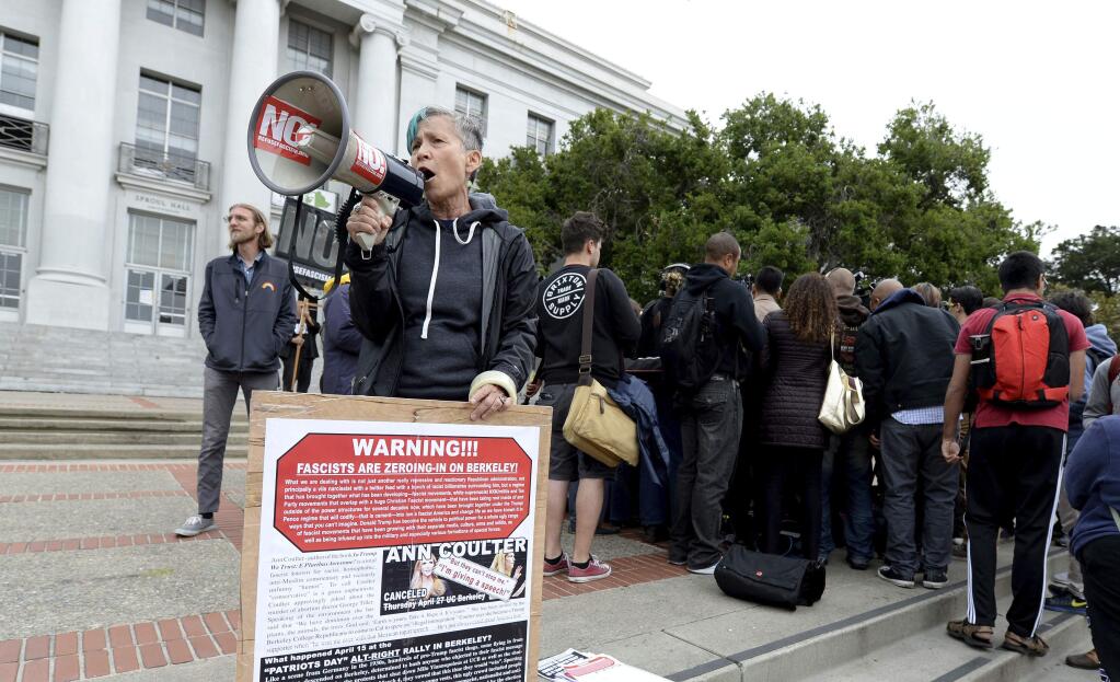 A protester uses a bullhorn to make her feelings known during a press conference held by the Berkeley College Republicans in Sproul Plaza on the UC Berkeley campus in Berkeley, Calif., on Wednesday, April 26, 2017. The event was held to discuss the cancellation of speaker Ann Coulter's appearance on campus. (Dan Honda/East Bay Times via AP)