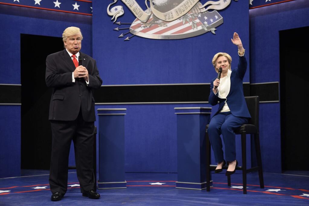 In this Oct. 15, 2016 photo provided by NBC, Alec Baldwin, left, as Republican presidential candidate, Donald Trump, and Kate McKinnon, as Democratic presidential candidate, Hillary Clinton, perform during the during the 'Debate Cold Open' sketch. Republican presidential candidate Donald Trump tweeted early Sunday morning, Oct. 16 that the show's skit depicting him this week was a “hit job.” Trump went on to write that it's “time to retire” the show, calling it “boring and unfunny” and adding that Alec Baldwin's portrayal of him “stinks.”(Will Heath/NBC via AP)