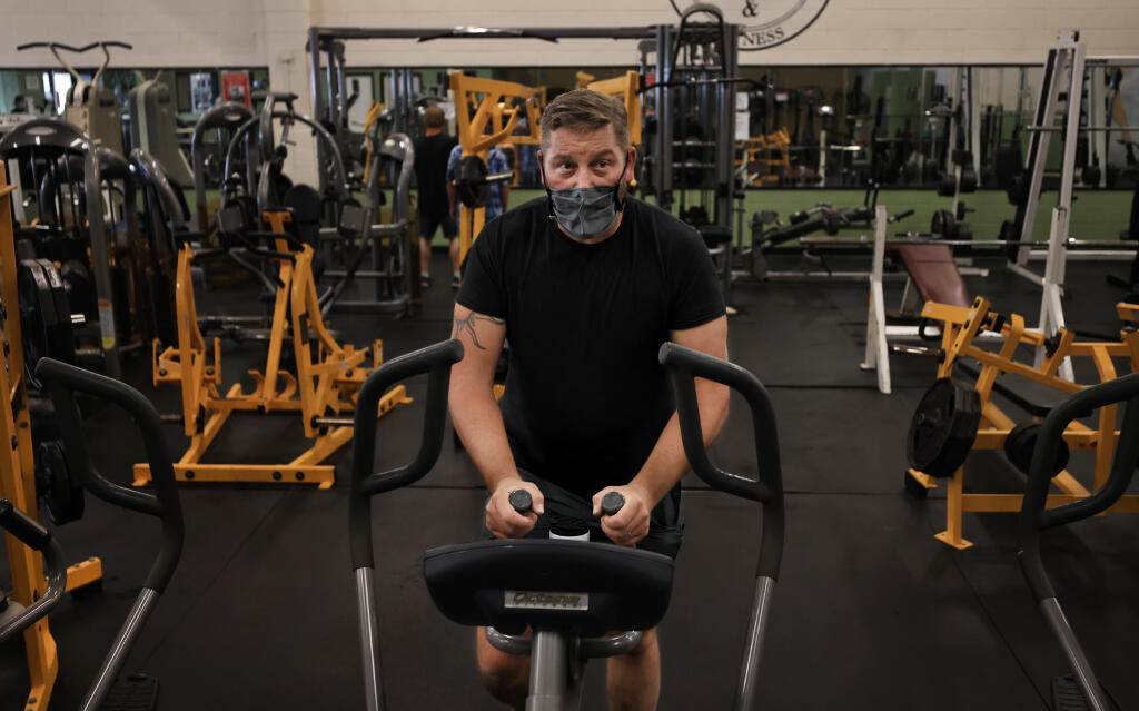 Karl Lienau of Santa Rosa keeps his mask on in accordance with county protocol as he cross trains on an elliptical, Thursday, October, 7, 2021, at Stan Bennett's Health and Fitness. (Kent Porter / The Press Democrat)