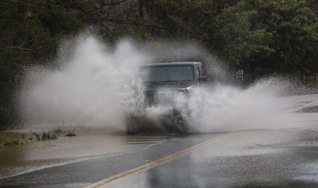 A car fords through a flooded Broadway south of Watmaugh Road. Heavy overnight rain brought flooding to some areas of Sonoma on Monday morning, Jan. 9, 2023. (Robbi Pengelly/Index-Tribune)