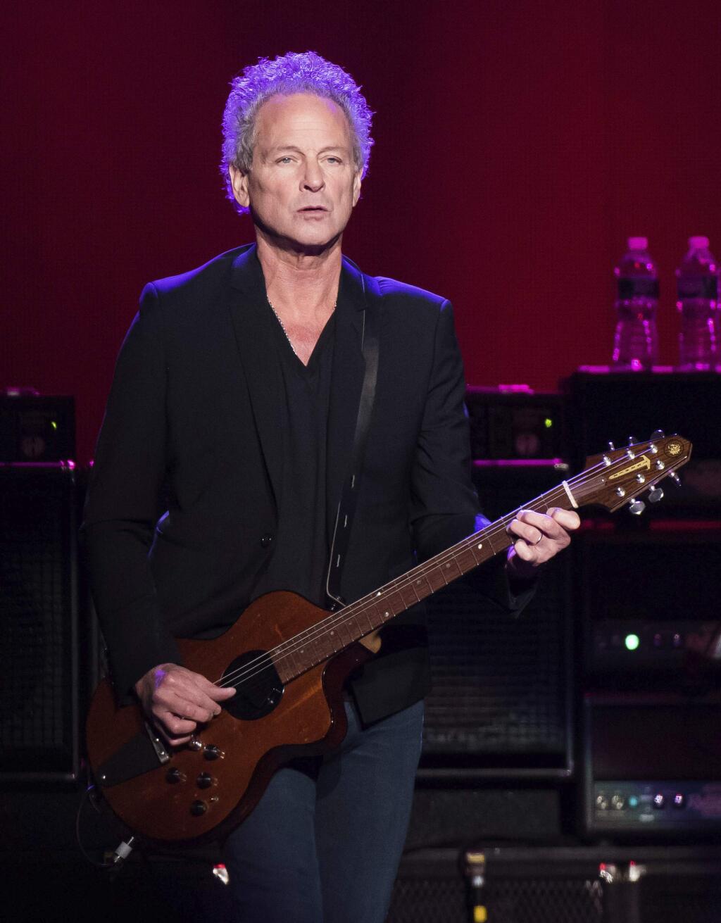 FILE - In this Oct. 6, 2014 file photo, Lindsey Buckingham from the band Fleetwood Mac performs at Madison Square Garden in New York. The band said in a statement Monday that Buckingham is out of the band for its upcoming tour. Buckingham left the group once before, from 1987 to 1996. He‚Äôll be jointly replaced by Neil Finn of Crowded House and Mike Campbell of Tom Petty and the Heartbreakers. (Photo by Charles Sykes/Invision/AP, FIle)