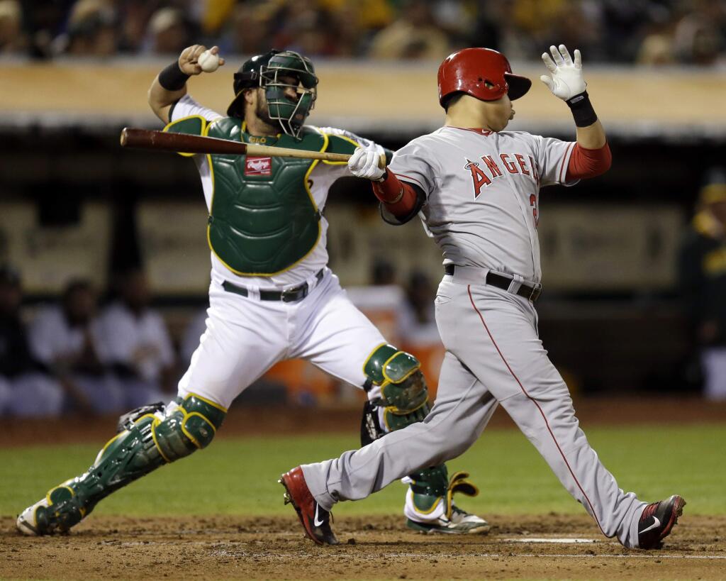 Los Angeles Angels' Hank Conger strikes out swinging as Oakland Athletics catcher Geovany Soto, left, throws to second base in the second inning of a baseball game Tuesday, Sept. 23, 2014, in Oakland. (AP Photo/Ben Margot)