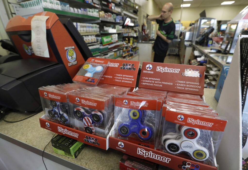In a Tuesday, May 9, 2017, photo, fidget spinner toys are displayed at a 7-Eleven convenience store, in Warren, Mich. Stores can't keep them in stock and parents are going crazy trying to find them. (AP Photo/Carlos Osorio)