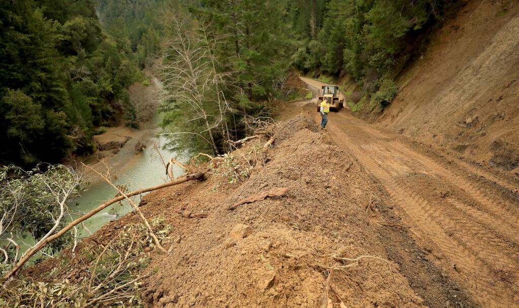The Wheatfield fork of the Gualala River borders the edge of a massive slide that buried Stewarts Point Skaggs Springs Road, Tuesday, March 5, 2019, under 20 feet of mud during the storm last week. (Kent Porter / The Press Democrat) 2019