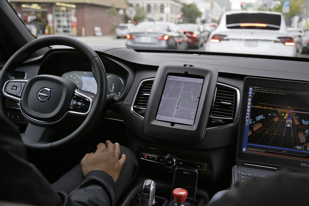 FILE - In this Tuesday, Dec. 13, 2016 file photo, an Uber car in driverless mode waits in traffic during a test drive in San Francisco. (AP Photo/Eric Risberg, File)