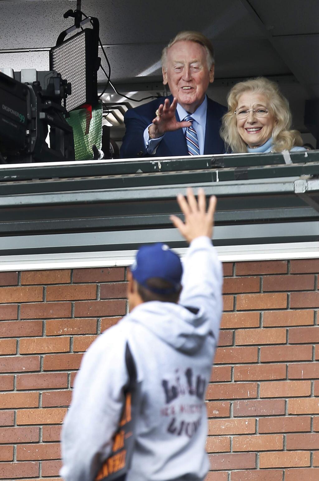 Los Angeles Dodgers announcer Vin Scully with his wife Sandi, waves to a fan before a baseball game between the San Francisco Giants and the Dodgers in San Francisco, Sunday, Oct. 2, 2016. (AP Photo/Tony Avelar)