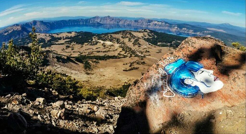 This undated photo taken from an Instagram posting shows an overlook of Crater Lake in Oregon with a rock painting. The National Park Service is investigating paintings and drawings of eerie faces found on rocks across the West in some of the country's most recognizable wilderness areas, including Crater Lake. (AP Photo/Instagram)