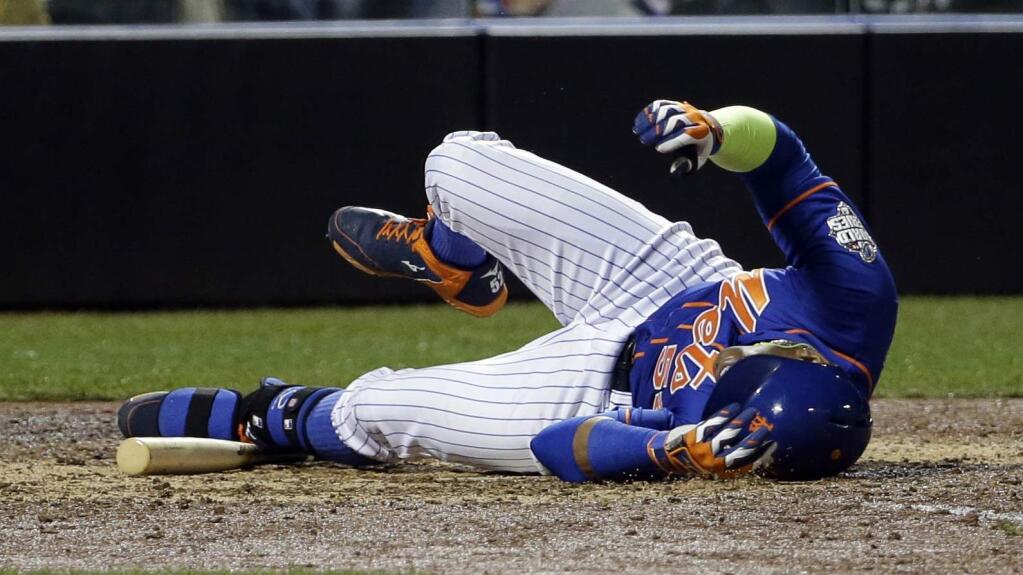 New York Mets' Yoenis Cespedes reacts after fouling a ball off his leg during the sixth inning of Game 5 of the Major League Baseball World Series against the Kansas City Royals Sunday, Nov. 1, 2015, in New York. (AP Photo/David J. Phillip)