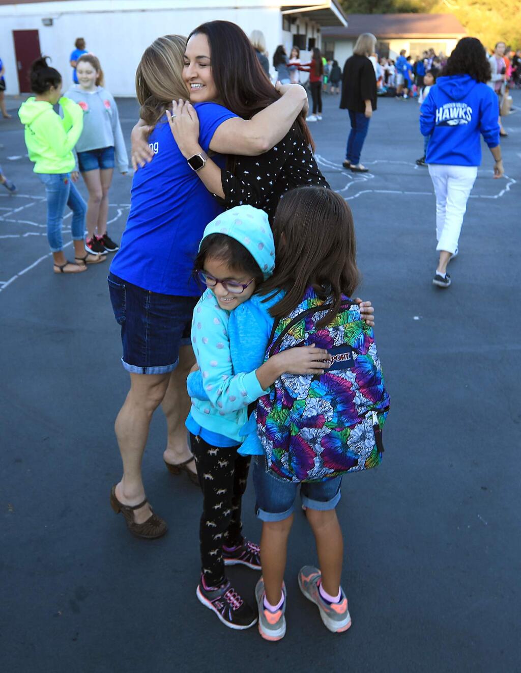 Marla Apodaca, Heidi Facciano, Maya Apodaca, 7, and Dania Farooqui 6, embrace at Hidden Valley Elementary School after it reopened nearly three weeks after the Tubbs fire razed portions of Santa Rosa, Friday Oct. 27, 2017. (Kent Porter / Press Democrat) 2017