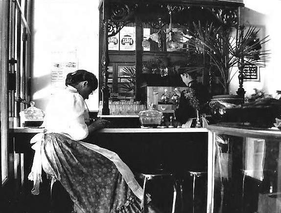 An interior photo of a soda fountain with woman seated at the counter and another woman behind the counter in Worth's Drugstore in Sebastopol in 1903. (Courtesy of the Western Sonoma County Historical Society)
