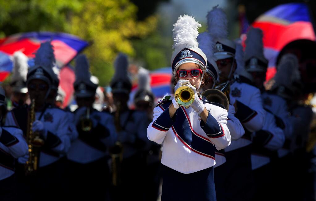 Alexander Brown, a trumpeter in the Rancho Cotate High School marching band, emerges from the shadows in the 2018 Santa Rosa Rose Parade on Saturday. (photo by John Burgess/The Press Democrat)