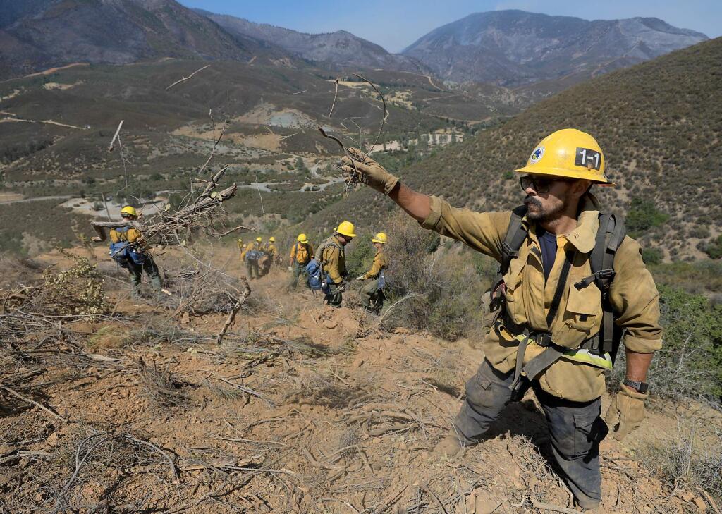 Ventura firefighte Rob leads a group of Army personnel with the Joint Base Lewis-McChord Lancer Brigade of Washington State, in rehabilitating a dozer line on the Ranch fire of the Mendocino Complex, Thursday, Aug. 30, 2018 near Fouts Springs in the Mendocino National Forest. In the background is the Snow Mountain Wilderness and St. John Mountain. (Kent Porter / The Press Democrat) 2018