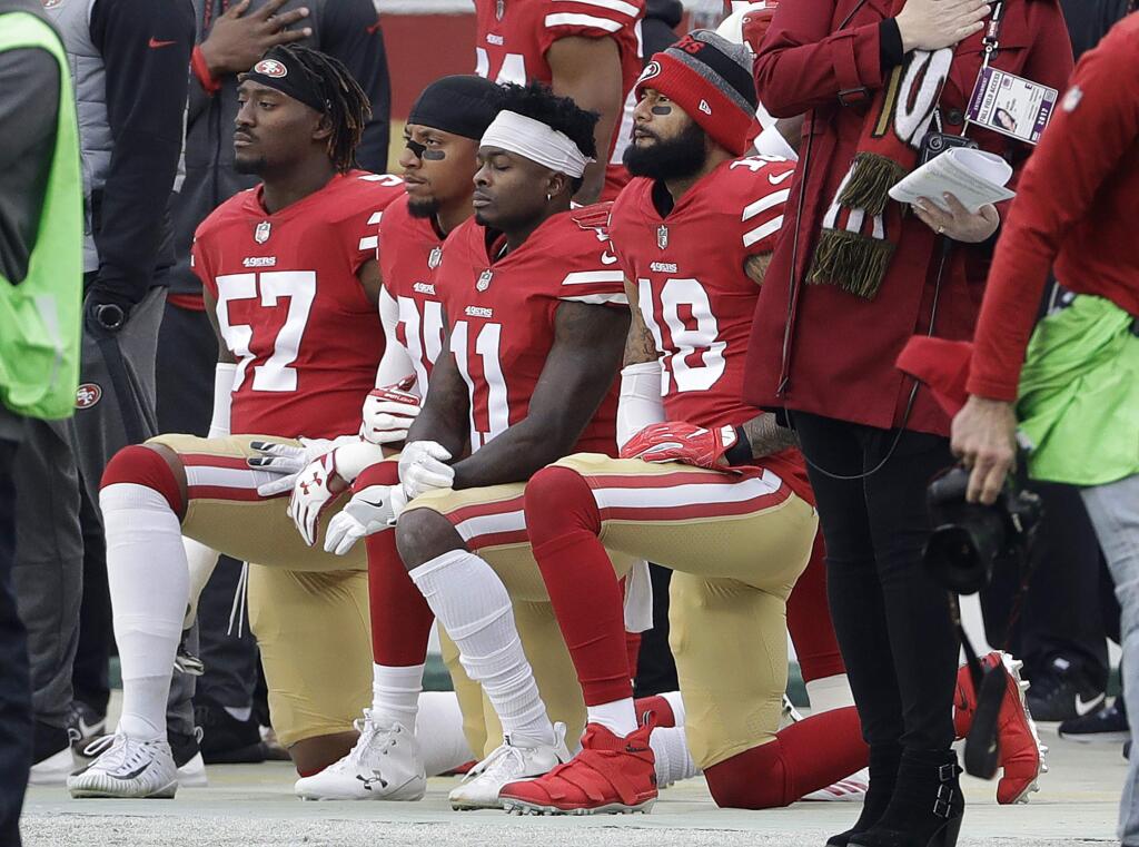 San Francisco 49ers outside linebacker Eli Harold, from left, kneels with safety Eric Reid, wide receiver Marquise Goodwin and wide receiver Louis Murphy during the national anthem before a game against the Jacksonville Jaguars in Santa Clara on Sunday, Dec. 24, 2017. (AP Photo/Jeff Chiu)