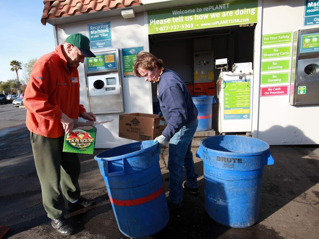 Brian Reynolds, right, helps a customer with his recyclables at rePlanet in Santa Rosa on Yulupa Avenue at Bethards Drive on March 1, 2012. (Press Democrat photo)