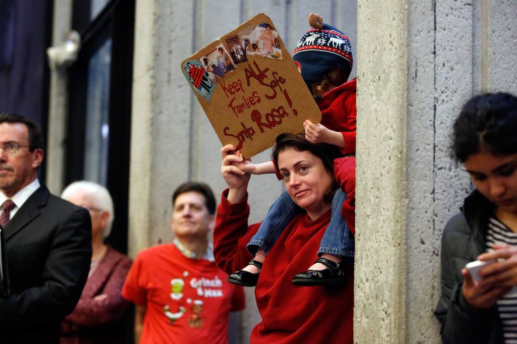 Cara Baum and her daughter Sirsha, 2, hold a sign in support of giving safe haven to undocumented immigrants during a city council meeting discussing the sanctuary city proposal in Santa Rosa, California on Tuesday, February 7, 2017. (Alvin Jornada / The Press Democrat)