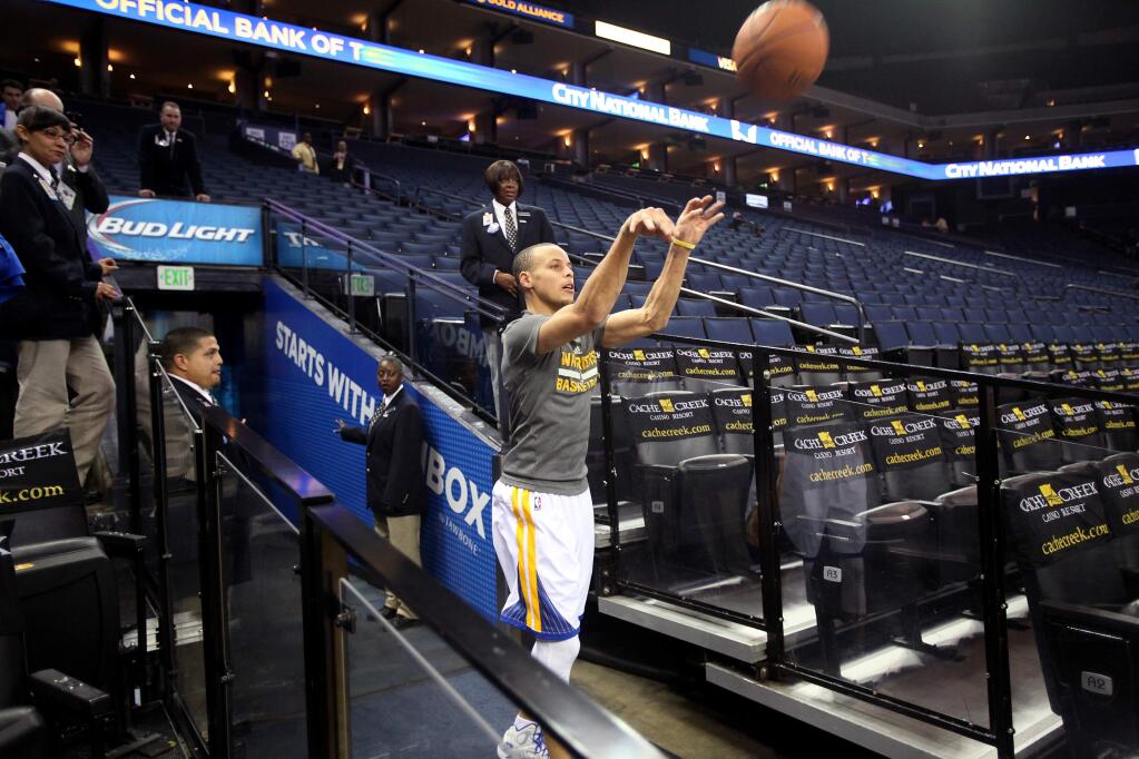Golden State Warriors guard Stephen Curry attempts a shot from near the tunnel at Oracle Arena after shooting practice, before facing the Miami Heat in Oakland on Wednesday, February 12, 2014. (Christopher Chung/ The Press Democrat)