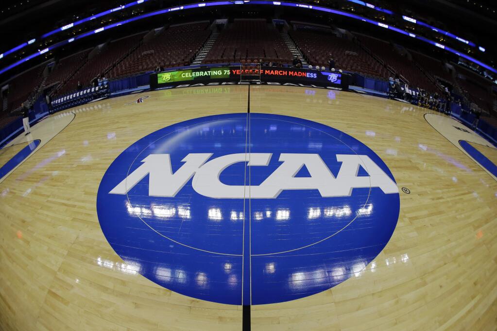 In this March 21, 2013, file photo, the NCAA logo is displayed on the court during the NCAA tournament in Philadelphia. College basketball players who go undrafted by the NBA will be allowed to return to school and play as part of sweeping NCAA reforms in the wake of a corruption scandal, the NCAA announced Wednesday, Aug. 8, 2018. (AP Photo/Matt Slocum, File)