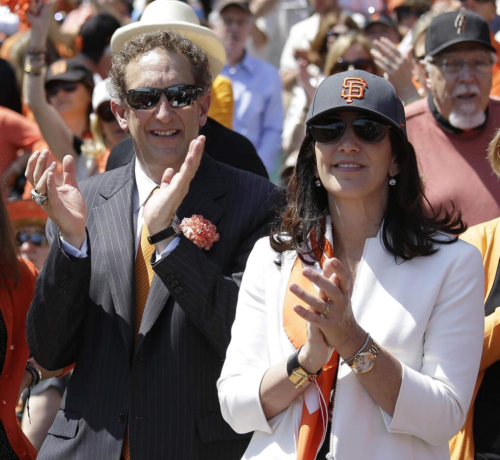 In this April 8, 2014, file photo, San Francisco Giants president and CEO Larry Baer, and his wife Pam, applaud before a game against the Arizona Diamondbacks in San Francisco. Baer is taking a leave of absence from the team following the release of a video showing him in a physical altercation with his wife. (AP Photo/Eric Risberg, File)