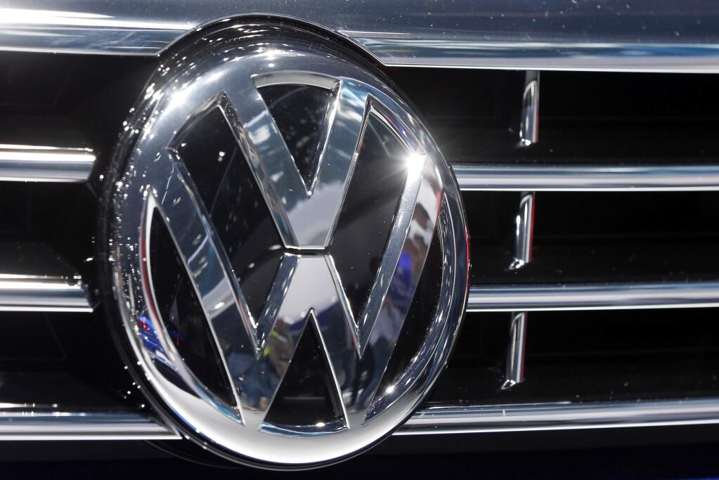 FILE - In this Sept. 22, 2015, file photo, the Volkswagen logo is seen on a car during the Car Show in Frankfurt, Germany. Volkswagen's plan to fix most of its 2-liter diesel engines that cheat on emissions tests includes a computer software update and a larger catalytic converter to trap harmful nitrogen oxide, according to dealers who were briefed by executives on the matter. (AP Photo/Michael Probst, File)