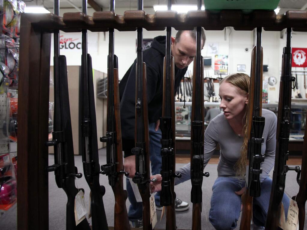 Sean Riley and Ellishea Roberts browse the rifle selection at Schmidt & Titoni Firearms & Accessories in Santa Rosa, on Wednesday, January 16, 2013.(Christopher Chung/ The Press Democrat)