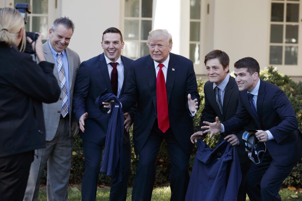 President Donald Trump poses for photographs with the Penn State wrestling team as he meets with NCAA championship teams at the White House, Friday, Nov. 17, 2017, in Washington. (AP Photo/Evan Vucci)
