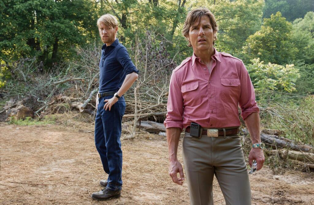 Tom Cruise as airline pilot Barry Seal recruited by the CIA and agent Mony Schafer (Domhnall Gleeson, left) for a CIA operation in Central America in the 1970s in 'American Made.' (Universal Pictures)