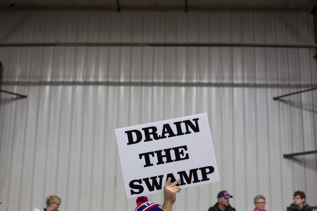FILE - In this Oct. 27, 2016, file photo, supporters of then-Republican presidential candidate Donald Trump hold signs during a campaign rally in Springfield, Ohio. Despite President Donald Trump's campaign to “drain the swamp” of lobbyists and special interests, Washington's influence industry is alive and well _ and growing. Former members of the Trump transition team, presidential campaign, administration and friends have set up shop as lobbyists and cashed in on connections, according to a new analysis by Public Citizen, a public interest group, and reviewed by The Associated Press. (AP Photo/ Evan Vucci, file)