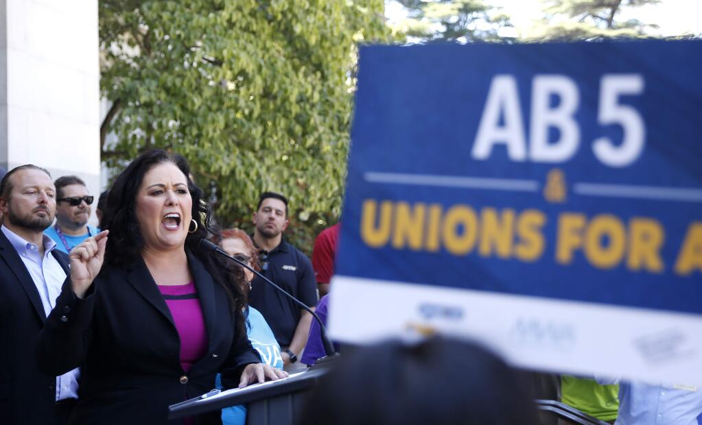 FILE - In this July 10, 2019, file photo, Assemblywoman Lorena Gonzalez, D-San Diego, speaks at a rally after her measure to limit when companies can label workers as independent contractors was approved by a Senate committee, in Sacramento, Calif. California lawmakers will return to work after their summer recess, Monday, Aug. 12, 2019, with one month left to pass bills before adjourning for the year. Among the legislation still to be decided on is Gonzalez's AB5, which would force companies like Uber and Lyft to treat their drivers like full-time employees. (AP Photo/Rich Pedroncelli, File)