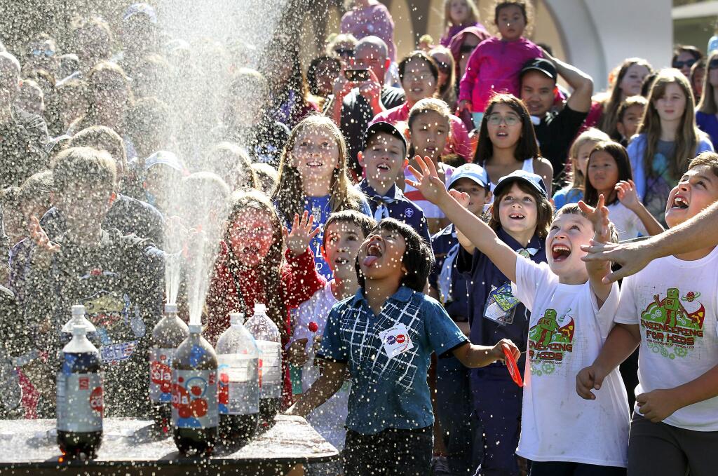 Children are sprayed with flat soda after adding Mentos at the North Bay Science Discovery Day at the Sonoma County Fairgrounds on Saturday, November 1, 2014.