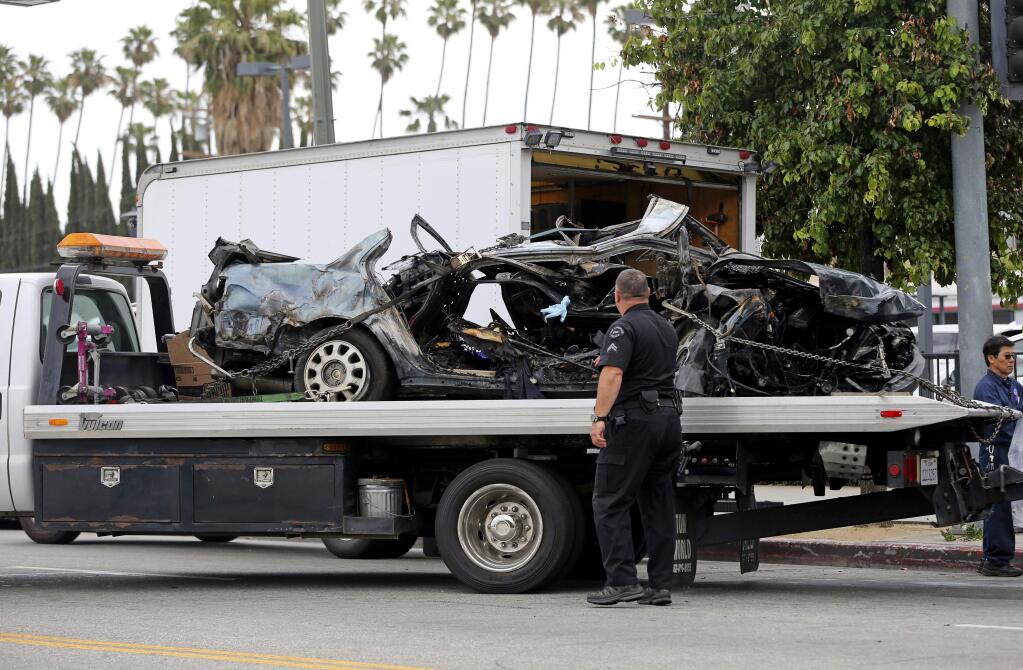FILE--In this May 14, 2017, file photo, a Los Angeles police investigator stands at the scene of a fiery crash after a high speed chase that killed two stolen-car suspects in Los Angeles. The California Supreme Court has rejected a lawsuit that could have made it easier to hold police liable for crashes during pursuits. The court ruled unanimously on Monday that law enforcement agencies in the state are protected from lawsuits in those cases even if every officer has not attested to having read the agency's pursuit policy. (AP Photo/Reed Saxon, file)