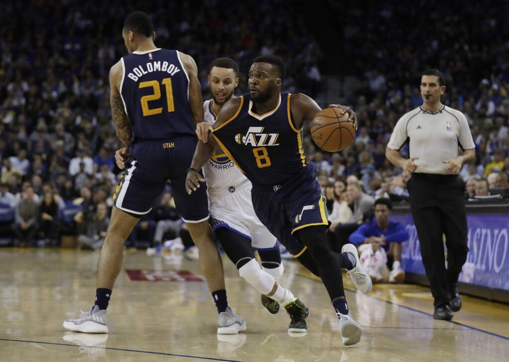 Utah Jazz guard Shelvin Mack dribbles around Golden State Warriors guard Stephen Curry, center, on a screen set by Joel Bolomboy during the second half Monday, April 10, 2017, in Oakland. (AP Photo/Marcio Jose Sanchez)