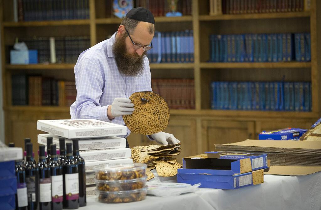 Rabbi Mendel Wolvovsky prepares packages with the key ingredients for a Seder dinner at home during the pandemic at the Chabad Jewish Center of Santa Rosa on Tuesday, April 7, 2020. Seder is a traditional ceremonial dinner on the first night of Passover. (John Burgess/The Press Democrat)