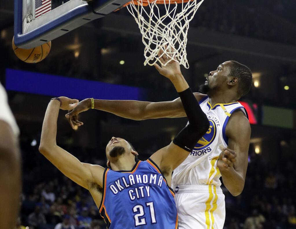Golden State Warriors' Kevin Durant, right, blocks a shot from Oklahoma City Thunder's Andre Roberson during the first half Wednesday, Jan. 18, 2017, in Oakland. (AP Photo/Marcio Jose Sanchez)