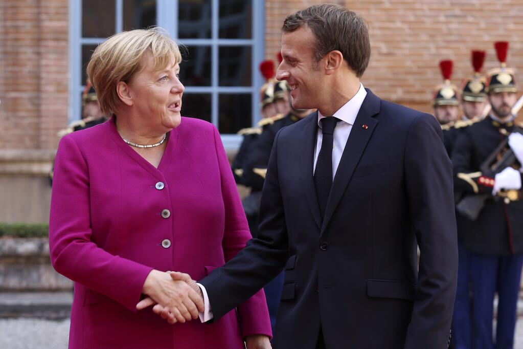 French President Emmanuel Macron welcomes German Chancellor Angela Merkel in the government building of Toulouse, southwestern France, Wednesday, Oct.16, 2019. President Emmanuel Macron and Chancellor Angela Merkel sought Wednesday to demonstrate the solidity of the French-German relationship at a meeting in southern France, one day before a key EU summit that may approve a divorce deal with Britain. (AP Photo/Frederic Scheiber)