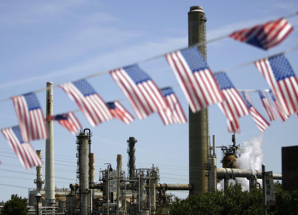 FILE - In this April 30, 2008 file photo, American flags are seen near the Shell refinery, in Martinez, Calif. California lawmakers moved closer to extending an ambitious climate change law, winning critical approval from business-minded Democratic lawmakers in the state Assembly after some encouragement from the White House. Opponents say doubling down on emissions reductions could raise gas prices or hurt the state's economy. (AP Photo/Ben Margot, File)
