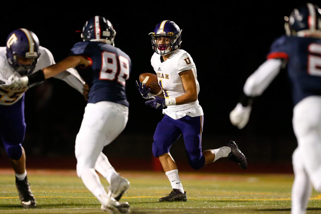 Ukiah's Jay Escamilla, center, runs with the ball during the first half between Ukiah and Rancho Cotate high schools in Rohnert Park on Friday, Oct. 26, 2018. (Alvin Jornada / The Press Democrat)