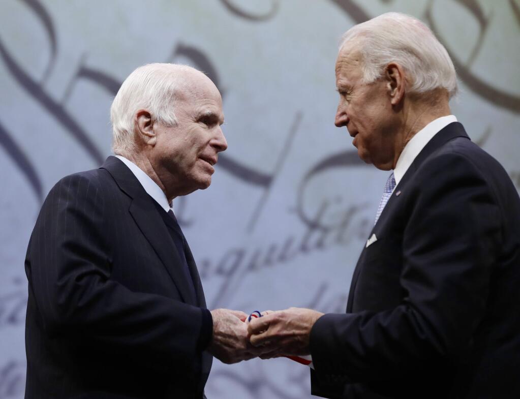 Sen. John McCain, R-Ariz., receives the Liberty Medal from Chair of the National Constitution Center's Board of Trustees, former Vice President Joe Biden, in Philadelphia, Monday, Oct. 16, 2017. The honor is given annually to an individual who displays courage and conviction while striving to secure liberty for people worldwide. (AP Photo/Matt Rourke)