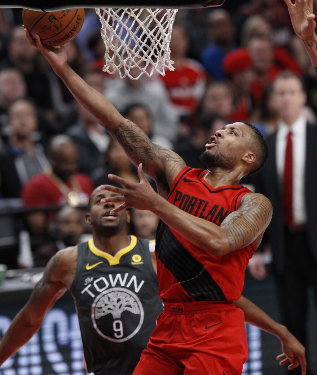Portland Trail Blazers guard Damian Lillard, right, drives past Golden State Warriors forward Andre Iguodala during the first half in Portland, Ore., Wednesday, Feb. 14, 2018. (AP Photo/Steve Dipaola)