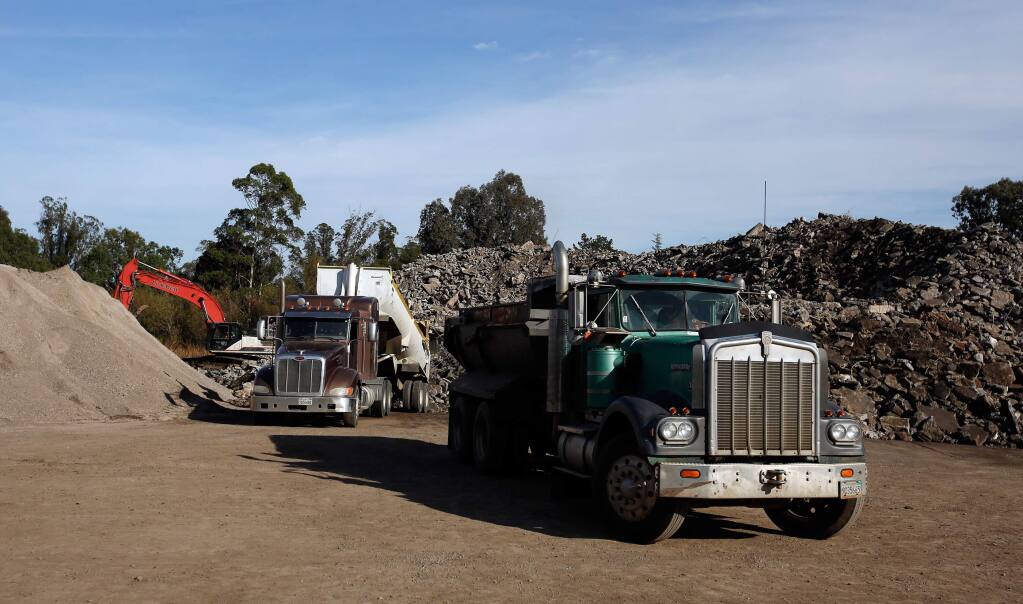A pair of dump trucks deposit loads of concrete at the Stony Point Rock Quarry in Cotati, California on Thursday, November 30, 2017. Structural concrete removed by the Army Corps of Engineers from sites destroyed by the wildfires are brought to Stony Point Rock Quarry for recycling. (Alvin Jornada / The Press Democrat)