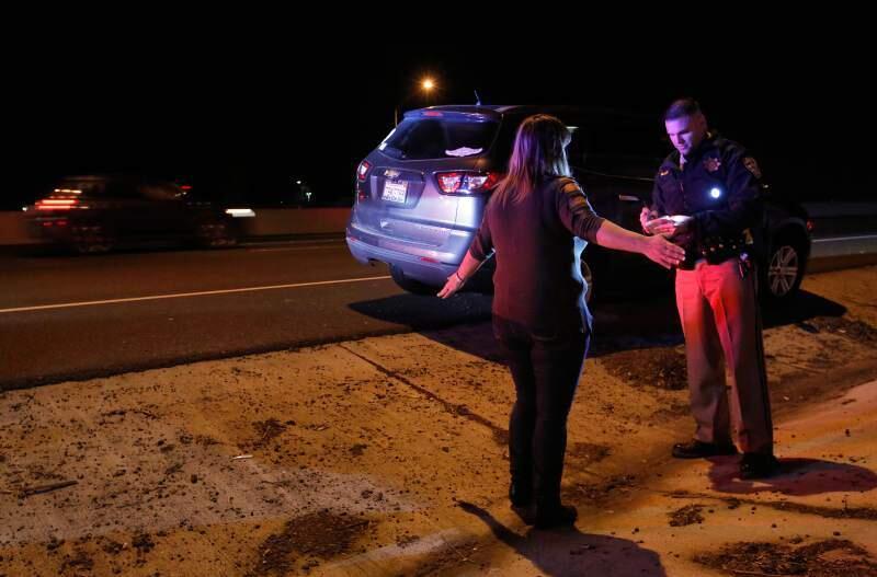 Josh Miller, a CHP officer, asks a driver to stand on one foot to determine her sobriety after she was pulled over for showing signs of driving under the influence of alcohol in June 2018. (ALVIN JORNADA/ PRESS DEMOCRAT)